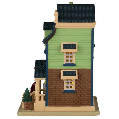 This image shows what the side of this house looks like. There are two windows. The siding is a pale neon green color and the brick is brown.