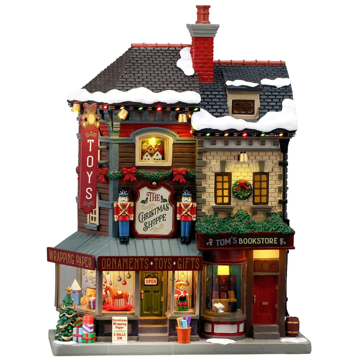 This image shows what this Lemax building looks like on a white background. It was designed to look like a tall shopping center made up of different shops. There's snow on the roof and on the sidewalk. There are nutcrackers, decorated wreaths and garlands and wrapped presents all over. Inside the window, you can see a bunch of different children's toys on display, like a rocking horse and a giant teddy bear dressed like Santa.