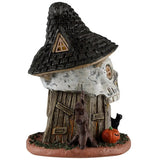 This is the side of this table accent. There's a window in the roof/hat. You can see a bare tree next to the door, along with a jack-o-lantern.