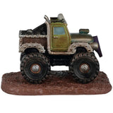 This image shows what the side of the truck looks like. It's a green monster truck but it's covered in dirt and mud.