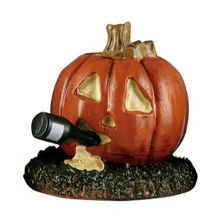 This Lemax accessory looks like a jack-o-lantern on a grassy patch. This pumpkin is drinking and there's a little bit of throw up underneath it.