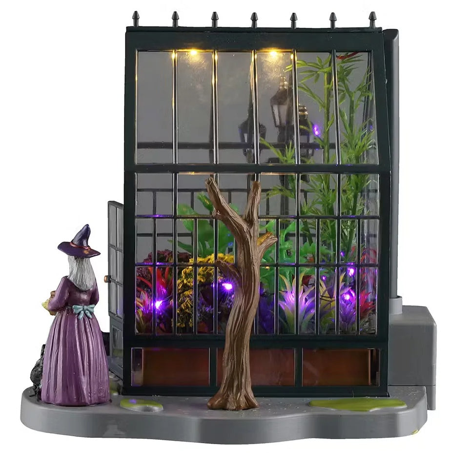 This is one of the other sides of the greenhouse. There's a bare tree and a witch outside.