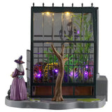 This is one of the other sides of the greenhouse. There's a bare tree and a witch outside.