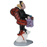 This image shows one of the figurines that was designed to look like a little girl and her dog out for trick or treating. The little girl is wearing a black turtleneck and black tights. She's also wearing red wings and a red tutu. The white dog is wearing smaller, matching red wings.