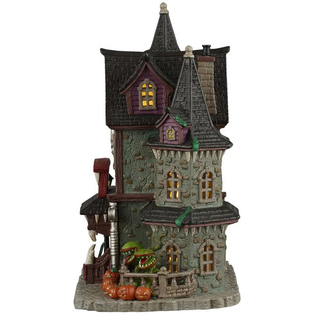 This image shows what the side of the lighted house looks like. You can see yellow lights from within the windows. You can also see more of the plants with the mouths and the teeth.