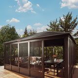 This image shows what this gazebo looks like on a wooden deck on a very sunny day. Inside the gazebo, there's a sectional couch with a coffee table, as well as a dining table.
