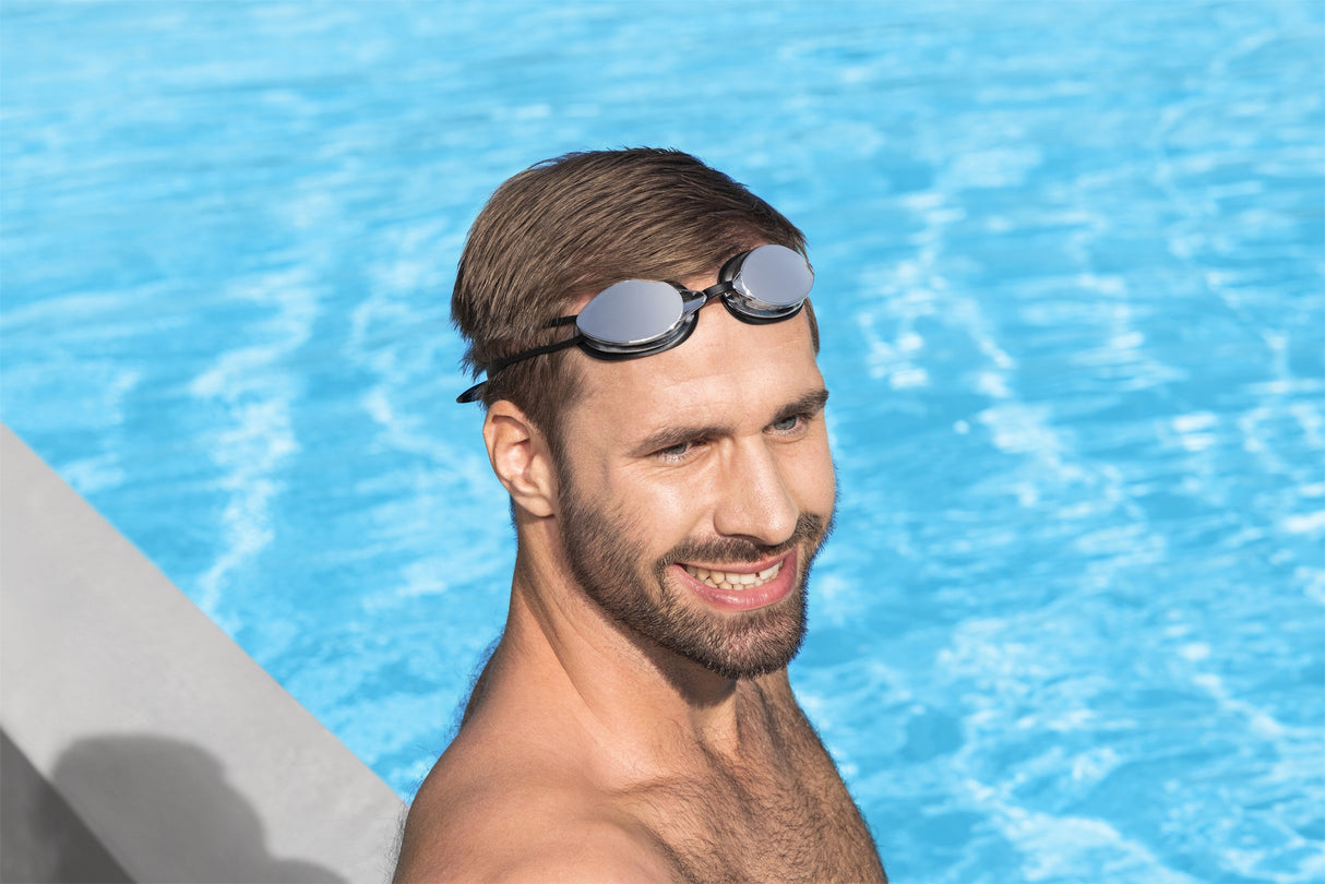 This image shows a man posing in the water wearing the black goggles on his forehead.