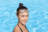 This image shows a woman posing in the water wearing the orange goggles on her forehead.