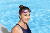 This image shows a woman posing in the water wearing the magenta goggles on her forehead.