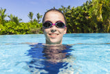 This image shows a woman swimming with her head above water wearing the magenta goggles.