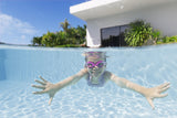 This is a lifestyle image showing a young girl swimming underwater wearing the magenta colored goggles.