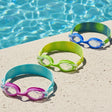 This is a lifestyle image showing all three of the color options available for these goggles laid out on the edge of a pool.