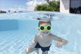 This is a lifestyle image showing a young boy smiling underwater wearing the neon yellow colored goggles.