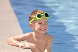This is a lifestyle image showing a young boy smiling at the camera with the neon yellow goggles around his forehead.