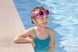 This is a lifestyle image showing a young girl smiling at the camera with the neon pink goggles around her forehead.