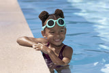 This is a lifestyle image showing a young girl smiling at the camera with the neon blue goggles around her forehead.