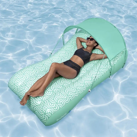 This is a lifestyle image showing a woman resting on the float in a pool. The float has the attachable sunshade on.
