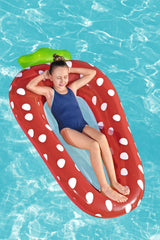 This is a lifestyle image showing a young girl sleeping inside the strawberry float in a pool.