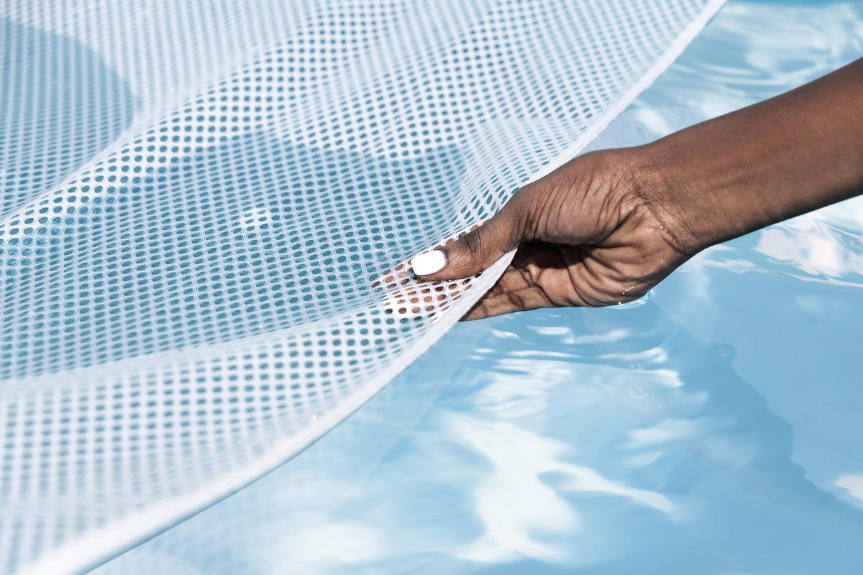 This image shows a hand gripping the mesh to show how it rests on the surface of the water.