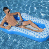 This is a lifestyle image showing a man resting inside the pool float in a pool.