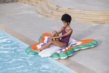 This is a lifestyle image showing a woman using this butterfly shaped pool float as a seat cushion next to a pool.