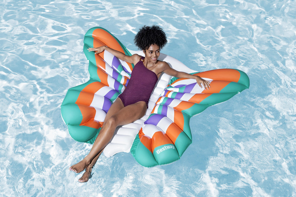 This is a lifestyle image showing a woman laying on the butterfly pool shaped float.