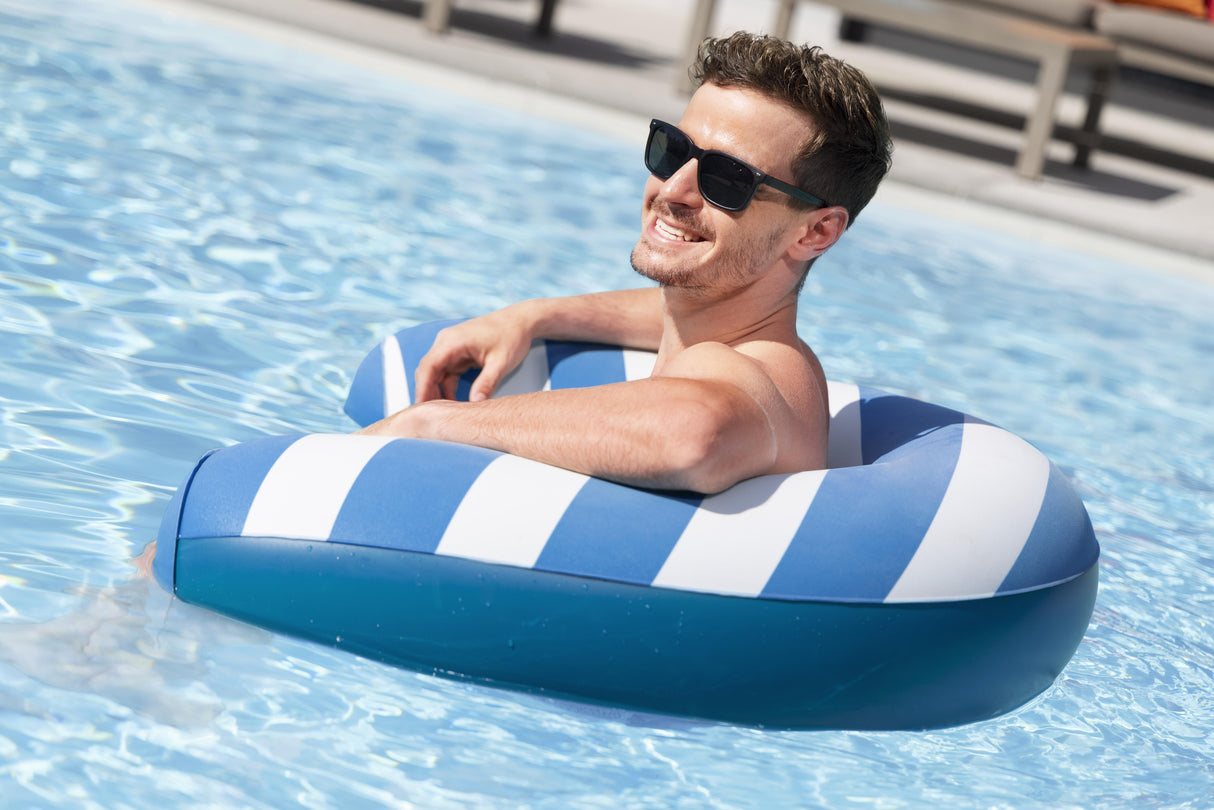 This is a lifestyle image showing a man sitting in the pool chair in the pool.