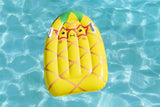 This is a lifestyle image showing the pineapple surf rider float in the water.