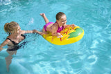 This is a lifestyle image showing a little girl holding onto the handles of the pineapple float while her mom holds the corner, keeping her afloat. 