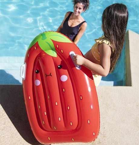 This is a lifestyle image showing a little girl holding the inflatable strawberry surf rider while going down the stairs into the pool, where her mom is waiting.