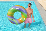 This is a lifestyle image of a man standing inside the pool and holding the inner tube on his side.