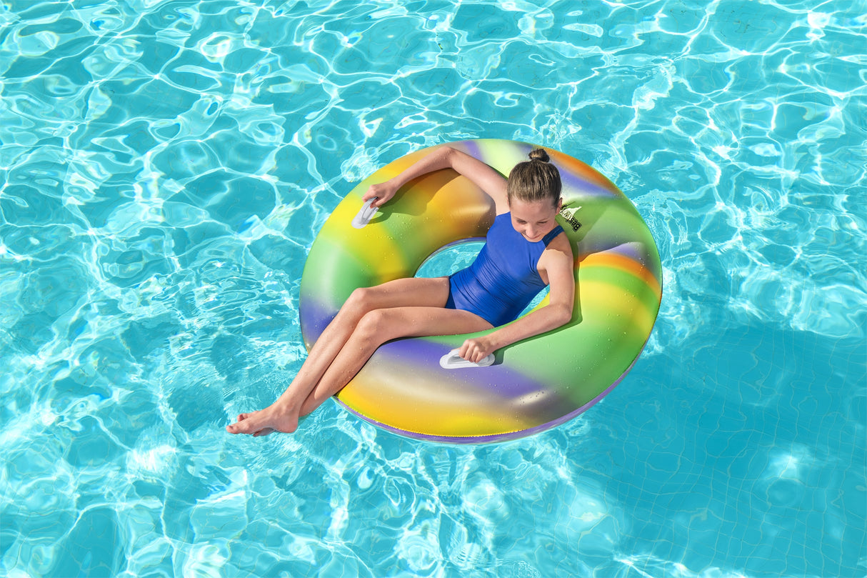 This is a lifestyle image showing a young girl sitting inside the inner tube in a pool.