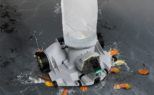 This is a lifestyle image showing the robotic pool cleaner in use, picking up leaves.
