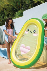 This is a lifestyle image showing a girl holding the avocado pool float on a pool deck.