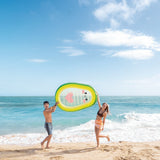 This is a lifestyle image showing two people at the beach holding up the avocado pool float.