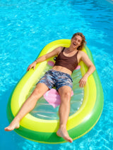 This is a lifestyle image showing a man laying on the pool float in a pool.
