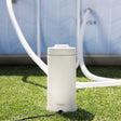 This is a lifestyle image showing the pool filter on the grass next to an Intex pool.