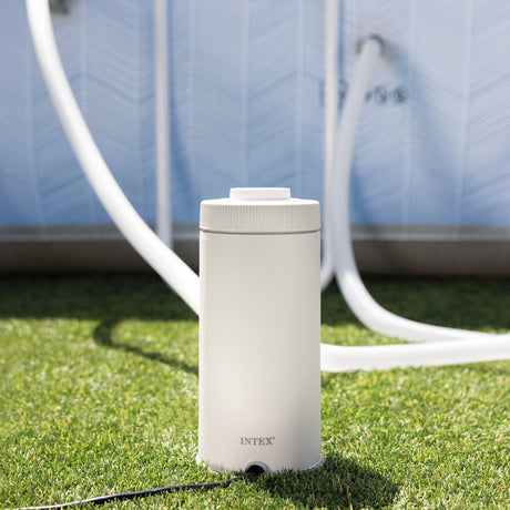 This is a lifestyle image showing the pool filter on the grass next to an Intex pool.