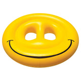 This image shows the smiley face pool float on a white background. The inflatable is round and yellow. The "eyes" are empty and the smile is large and black.