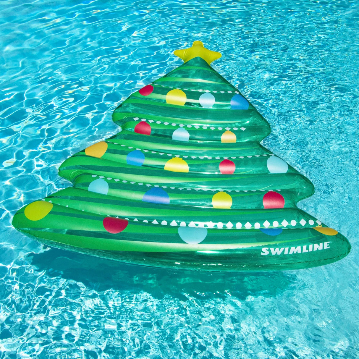 This is a lifestyle image showing the Christmas tree mattress floating in a pool.