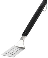 An up close view of this Napoleon spatula. The handle is black and at the top, features the Napoleon "fire" logo and at the bottom, it reads "NAPOLEON." The head of the spatula is stainless steel silver with three slightly wavy cut out lines. There's also a stainless steel hook at the end of the handle. 