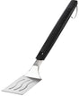 An up close view of this Napoleon spatula. The handle is black and at the top, features the Napoleon "fire" logo and at the bottom, it reads "NAPOLEON." The head of the spatula is stainless steel silver with three slightly wavy cut out lines. There's also a stainless steel hook at the end of the handle. 