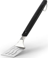 An up close view of this Napoleon spatula. The handle is black and at the top, features the Napoleon "fire" logo and at the bottom, it reads "NAPOLEON." The head of the spatula is stainless steel silver with three slightly wavy cut out lines. There's also a stainless steel hook at the end of the handle. This image has a shadow underneath the spatula head.
