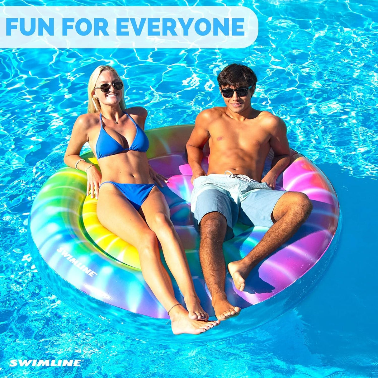 This is a lifestyle image showing two people lounging on this circular pool inflatable. It reads "Fun for everyone."