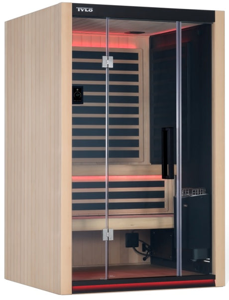 A light brown colored home sauna that fits 2 people. There are lights on inside and the lights are red.