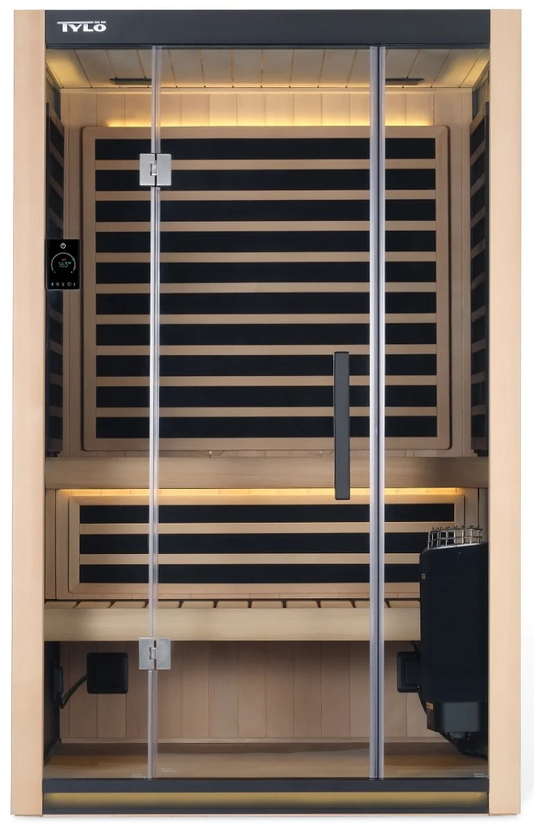 A light brown colored home sauna that fits 2 people. There are lights on inside and the lights are yellow.