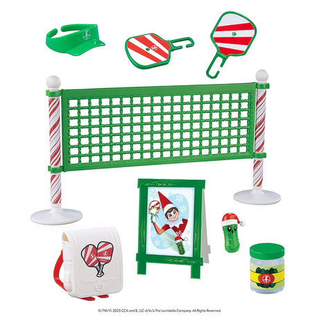 This image shows everything that comes in this pickleball pack. A green visor, two red and white striped paddles, a green net with candy cane poles, a white backpack with red paddles on it, a stand up sign that has an elf playing pickleball on it, a small pickle wearing a Santa hat and a small jar of pickles.