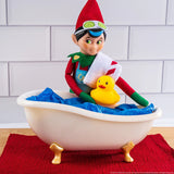 This is a lifestyle image showing a Scout Elf getting ready to get into the bathtub with the rubber ducky.