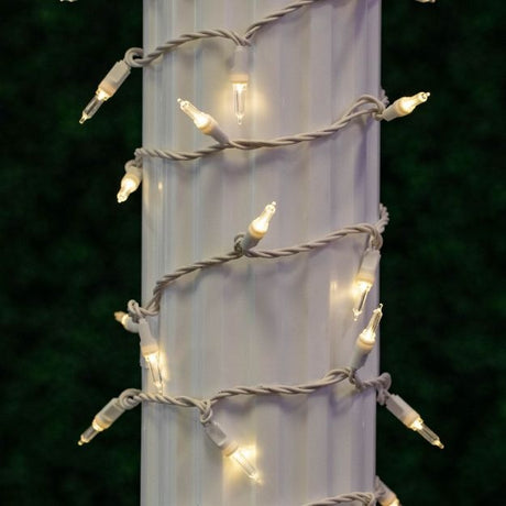 This is a lifestyle image showing these warm white lights on a white wire wrapped around a column outside.