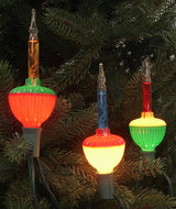 This is a lifestyle image showing three of the bubble lights on a tree. The lights are on.